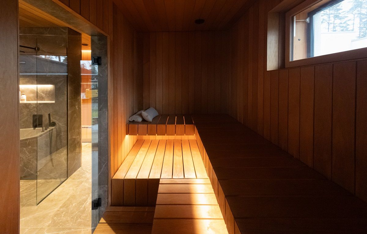 Una striscia LED da 7,2 W/m di tonalità calda in profilo di alluminio, montata sul lato inferiore della seduta della sauna.